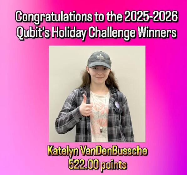Qubit's Holiday Challenge Winners (2025-2026) with 1st prize winner, Katelyn VanDenBussche. She is a light skinned individual, with long brown hair. She is wearing a grey baseball cap, a cream colored t-shirt with a faded graphic and a grey plaid button up
